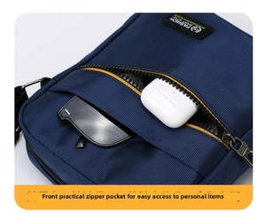 Detail view of navy blue nylon crossbody bag showing storage for earbuds and sunglasses