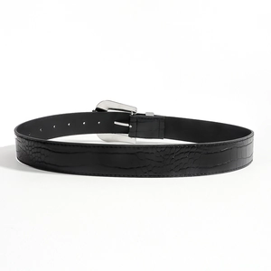 Detail of black belt with crocodile texture and polished silver metal pin buckle
