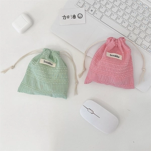 Close-up of seersucker texture on mint and pink drawstring pouches with Sozakka label
