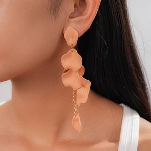 Detail shot of long matte nude acrylic petal tassel earrings worn by a model