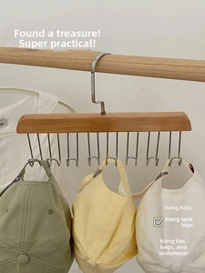 Detail of wooden hanger with ten metal U-shaped hooks organizing hats in a home setting
