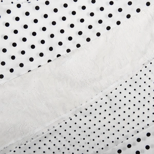 Detailed close-up showing polka dot fabric textures and white lace ribbon on a summer skirt