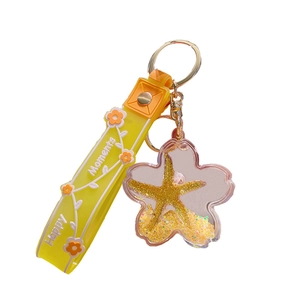 Floating liquid yellow flower keychain with gold starfish and happy moments strap