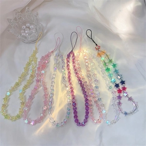 Colorful acrylic heart and star beaded phone straps on soft white fabric background