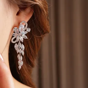 Elegant silver flower tassel earrings with sparkling crystals worn by a model