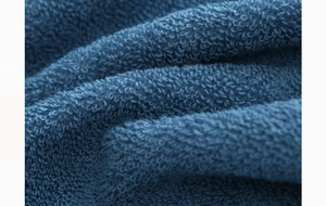 Macro shot of high-density blue cotton towel loops showing soft and absorbent texture