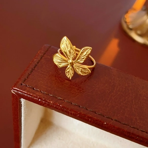 Detailed macro shot of golden butterfly ring on a brown leather luxury jewelry box edge