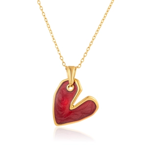 Dettaglio di un ciondolo a cuore vintage in smalto rosso su una sottile catena dorata