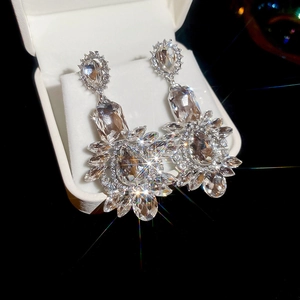 Macro shot of silver crystal flower earrings with starburst sparkle in a jewelry box