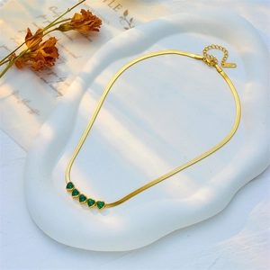 Golden herringbone snake chain necklace featuring five green heart-shaped gemstones