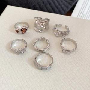 Macro detail of 7-piece silver resin ring set with rhinestones and vintage textures