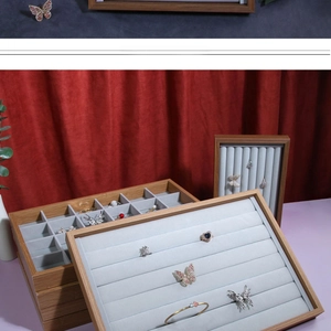 Macro detail of solid wood jewelry display stand with soft grey velvet lining inserts