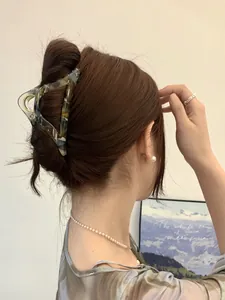 Detail showing an amber tortoiseshell triangle hair claw clip on back of head