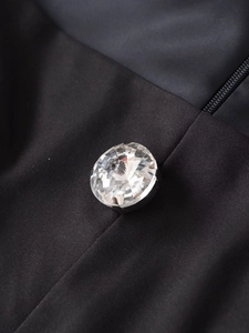 Détail du bouton élégant en strass sur tissu noir pour le combishort femme à la mode chic