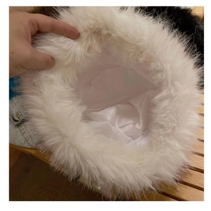Detailed view of the white plush faux fur bucket hat featuring a smooth silk inner lining