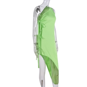 Détail de la robe asymétrique vert néon avec lacets latéraux et coupe irrégulière