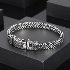 Close-up of vintage skull bracelet on black box showing intricate engraved metal buckle