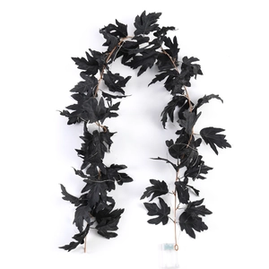 Detail of black artificial maple leaves with integrated LED string lights and battery box