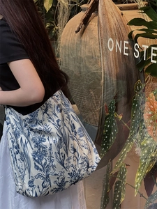 Close-up of a large canvas tote bag featuring blue and white floral tie-dye patterns