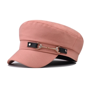 Detailed macro of pink cadet cap with leather strap, horsebit buckle and heart rhinestones