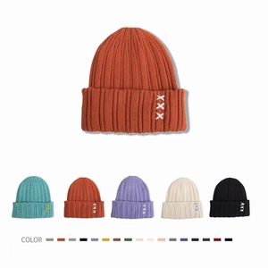 Detail view of ribbed knit beanies in multiple colors with side embroidery