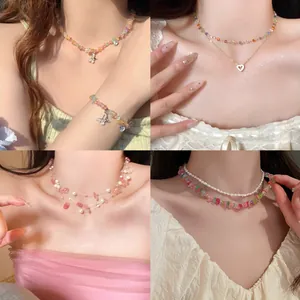 Detail of layered beaded necklaces featuring butterfly zircon pendants and pink stones