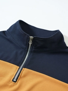 Gros plan du pull en maille gaufrée bleu marine et jaune avec col montant zippé vintage