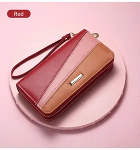 Detail of red and pink patchwork leather long wallet with dual zippers and wrist strap