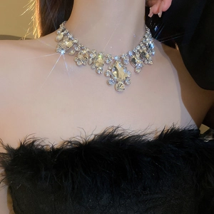 Close-up of sparkling silver tassel necklace with oversized teardrop crystals on model