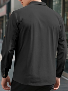 Detail of dark grey linen shirt showing fabric texture and buttons on sleeve and collar back