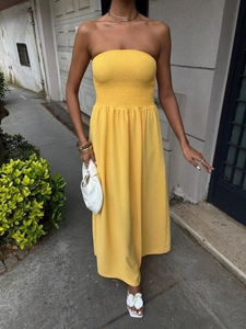 Close-up of smocked bodice and flowing A-line hem on this yellow strapless maxi dress