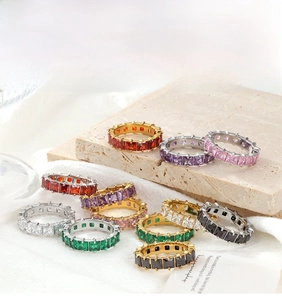 Macro view of eternity rings with colorful square-cut stones and gold and silver bands