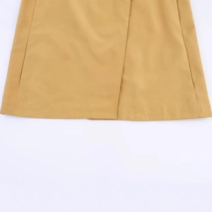 Minimalist short trench coat for women in ginger yellow color showing hemline detail