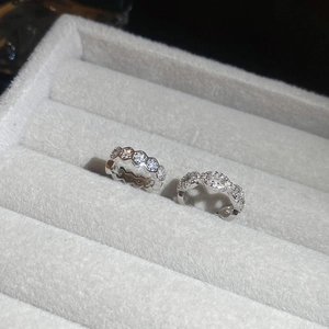 Macro detail of silver honeycomb and braided rings with white cubic zirconia in a jewelry box