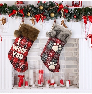 Detail of red and grey plaid pet Christmas stockings with faux fur trim on fireplace