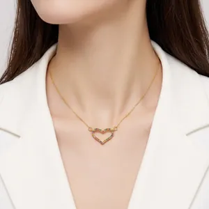 Elegant gold hollow heart necklace with rainbow gemstones on a model neck