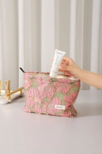 Detailed view of 3D pink floral jacquard fabric and metal zipper on the cosmetic bag