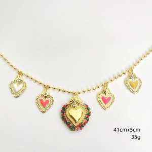Dettaglio della collana di perline dorate con ciondoli a cuore colorati e corona