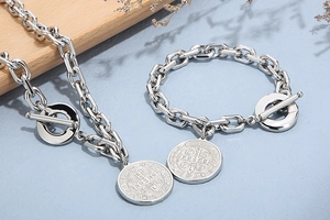 Detailed view of silver chunky chain set with St. Benedict medal pendants and toggle clasps