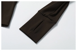 Close-up of dark brown yoga jacket sleeve with elastic fabric and functional thumbhole