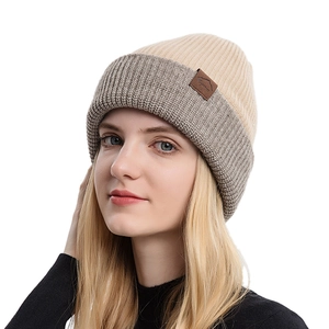 Unisex knit beanie in beige and grey color block with leather patch mountain logo