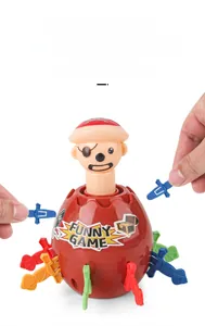 Close-up of hands inserting colorful plastic swords into the red pirate barrel game