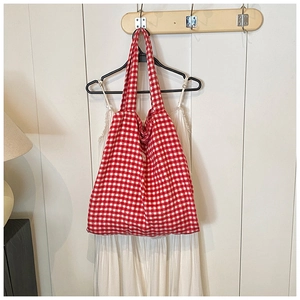 Detail of red and white checkered canvas tote bag hanging on a minimalist hanger