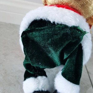 Detail of 30cm musical Santa doll showing red sequin hat and green velvet trousers fabric