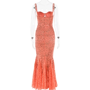Détail d'une robe moulante en dentelle corail avec motifs floraux et coupe sirène