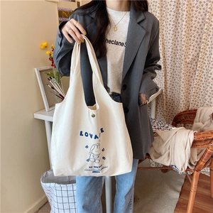 Détail du sac cabas en toile blanche avec imprimé dessin bleu et bouton pression bronze