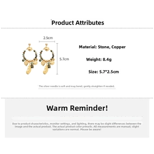 Detail view of 14K gold plated earrings with vintage stone beads and feather charms