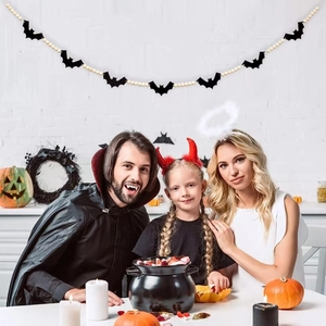 Close-up of Halloween bat tag wood beads garland hanging over a family in costumes