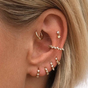 Close-up of stacked gold S925 silver earrings with sparkling cubic zirconia stones