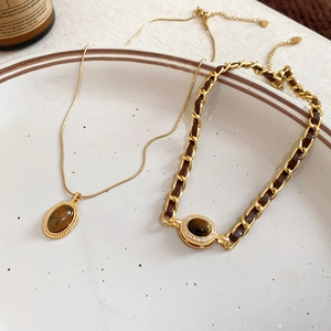 Dettaglio del set collana occhio di tigre placcato oro 18k e bracciale in pelle intrecciata